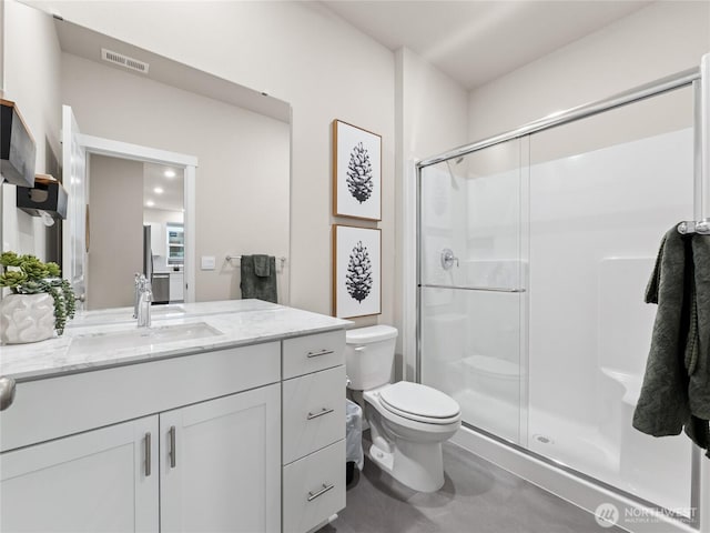 full bathroom featuring toilet, a stall shower, vanity, and visible vents