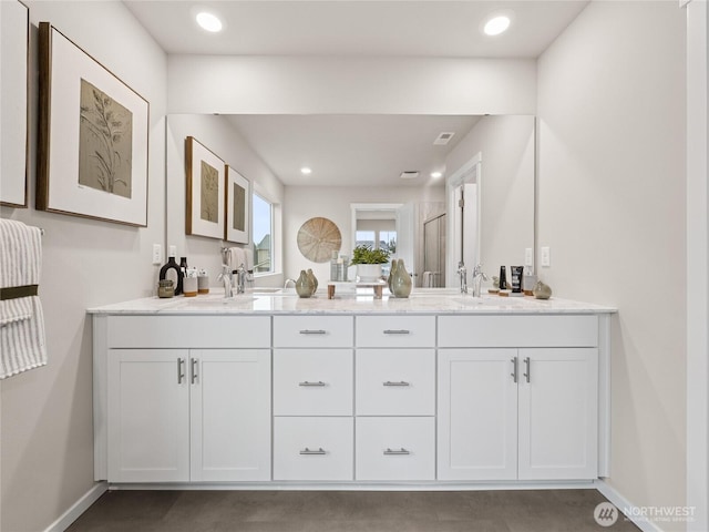 bathroom with recessed lighting, a sink, baseboards, and double vanity