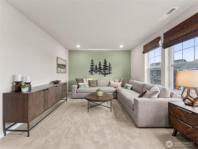 living area featuring recessed lighting, visible vents, and light carpet