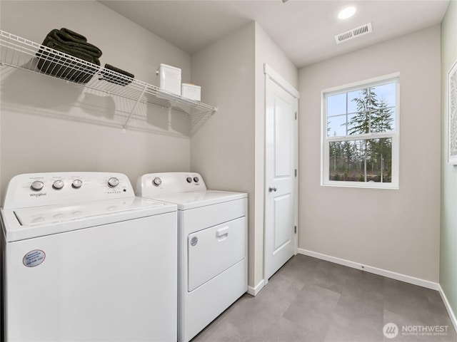 washroom featuring laundry area, washing machine and dryer, visible vents, and baseboards