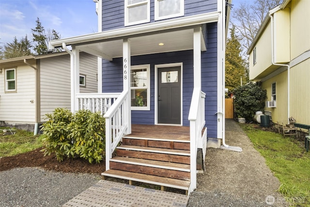 doorway to property with a porch and cooling unit