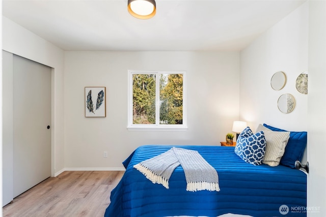 bedroom featuring a closet, wood finished floors, and baseboards