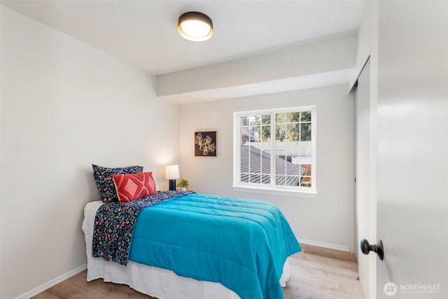 bedroom featuring wood finished floors and baseboards