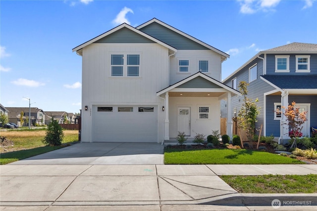 view of front of house featuring a garage, concrete driveway, and a front lawn