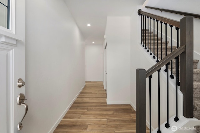 interior space with light wood finished floors, stairway, baseboards, and recessed lighting