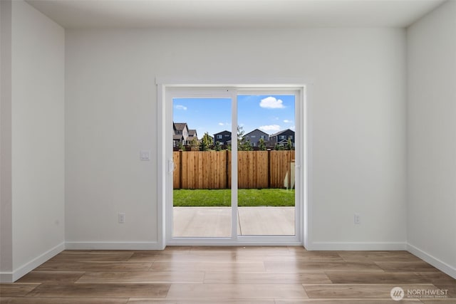 doorway with light wood-style flooring and baseboards