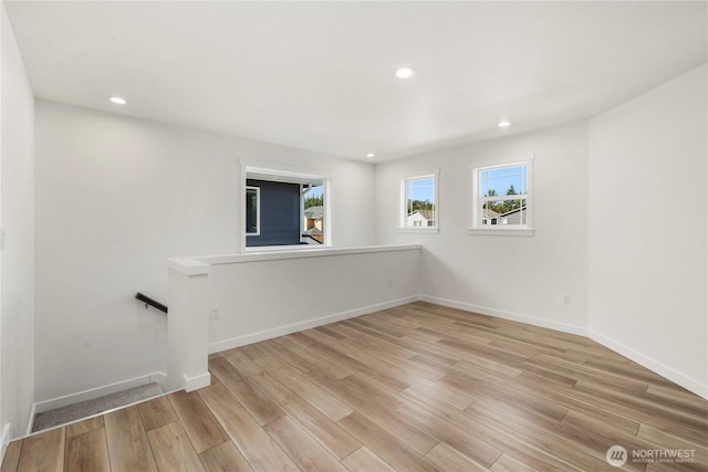 unfurnished room with light wood-style flooring, baseboards, and recessed lighting