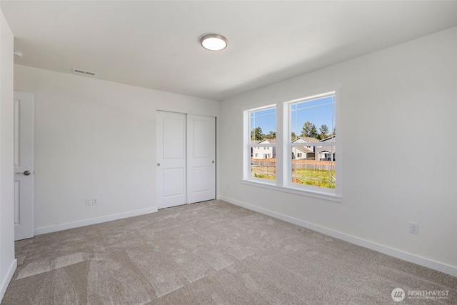 unfurnished bedroom featuring a closet, carpet flooring, and baseboards