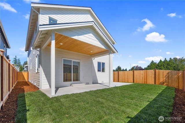 rear view of property with a yard, a fenced backyard, and a patio