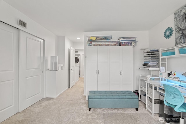 interior space with recessed lighting, light carpet, visible vents, baseboards, and stacked washing maching and dryer