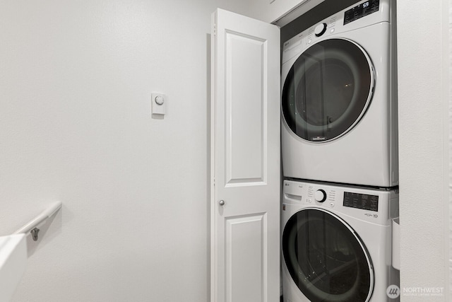 clothes washing area with stacked washer / dryer and laundry area