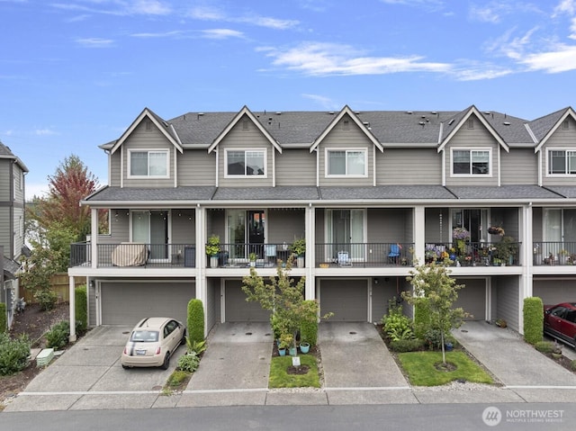 view of property with concrete driveway, roof with shingles, and an attached garage