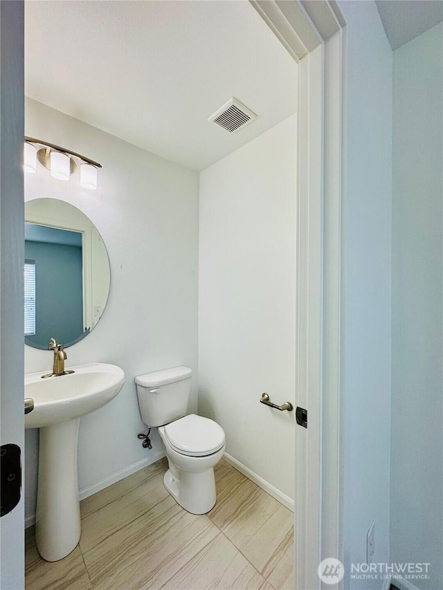 half bathroom featuring baseboards, visible vents, and toilet