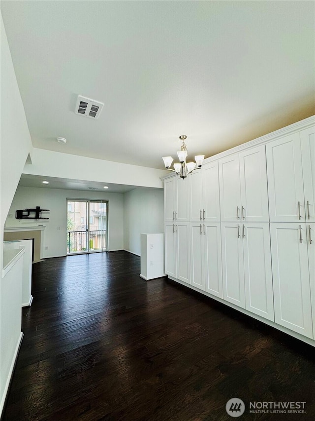 unfurnished living room with recessed lighting, visible vents, dark wood finished floors, and a chandelier