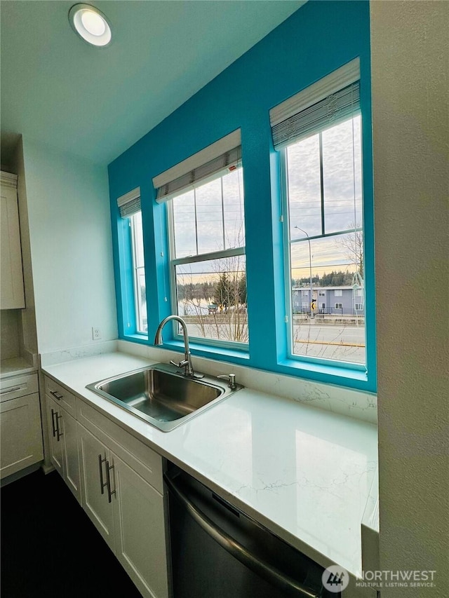 kitchen featuring light countertops, a sink, and dishwasher