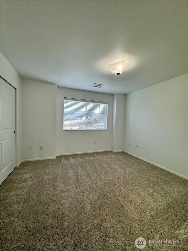 unfurnished bedroom with carpet floors, visible vents, and baseboards