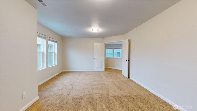 carpeted empty room featuring visible vents and baseboards