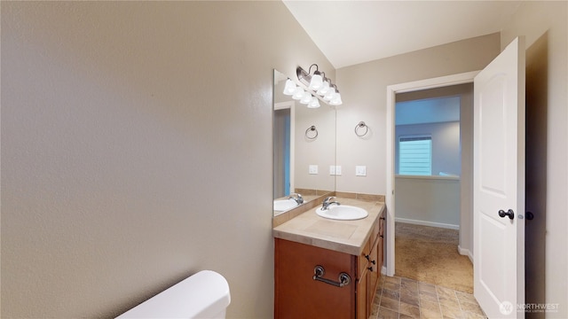 half bathroom with vanity, toilet, and baseboards