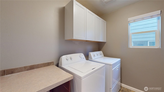 laundry room with cabinet space, baseboards, and separate washer and dryer