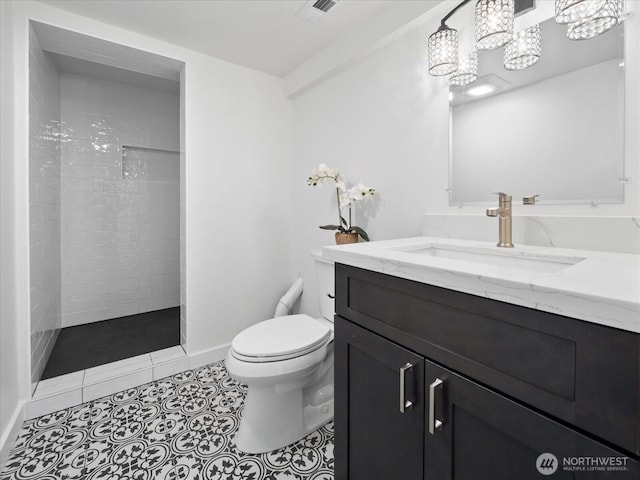 bathroom featuring visible vents, toilet, vanity, tile patterned flooring, and tiled shower