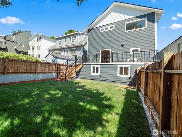 back of property featuring stairs, a lawn, a fenced backyard, and a residential view