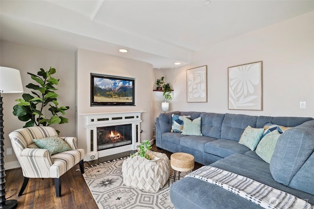 living room with a glass covered fireplace, recessed lighting, and wood finished floors