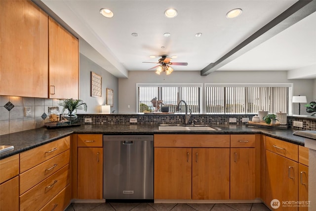 kitchen featuring light tile patterned floors, dishwasher, dark stone counters, and a sink