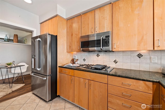 kitchen featuring stainless steel appliances, backsplash, light tile patterned flooring, and brown cabinetry