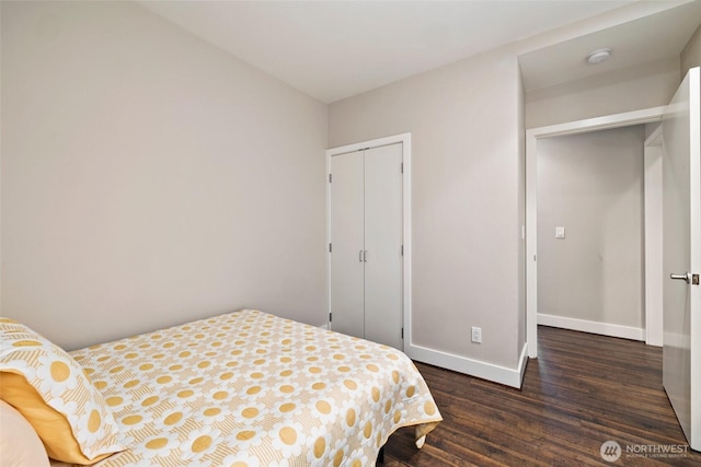 bedroom featuring a closet, baseboards, and dark wood-style flooring