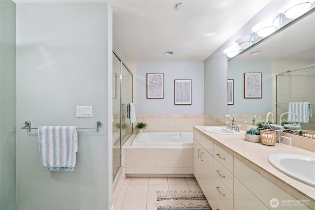 bathroom with tile patterned floors, a shower stall, a garden tub, and a sink