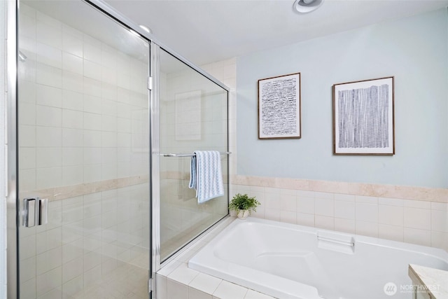 bathroom featuring a stall shower and a garden tub