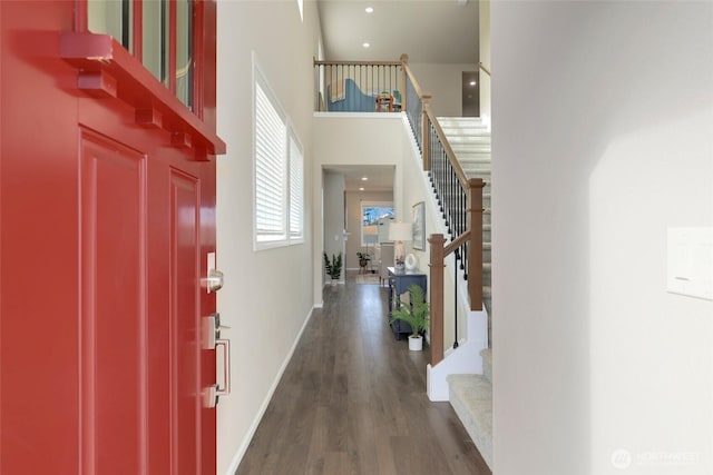 entrance foyer with baseboards, a high ceiling, stairway, and dark wood finished floors