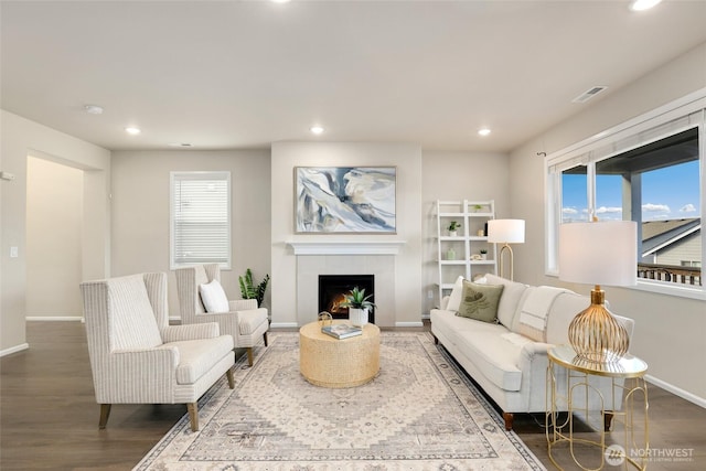 living room featuring recessed lighting, visible vents, baseboards, and wood finished floors