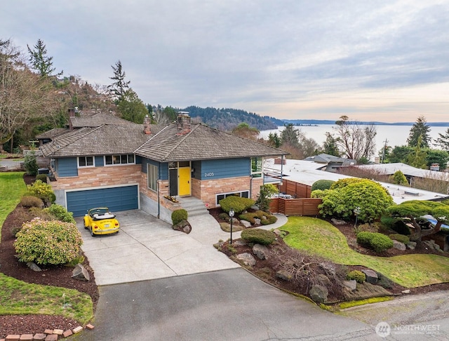 view of front of house featuring a garage, stone siding, fence, and concrete driveway