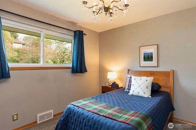 carpeted bedroom featuring visible vents, baseboards, and an inviting chandelier