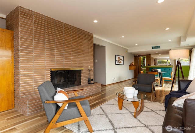 living room featuring baseboards, a fireplace, wood finished floors, and recessed lighting