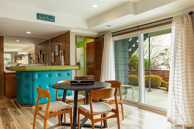 dining area with a bar, light wood finished floors, and recessed lighting