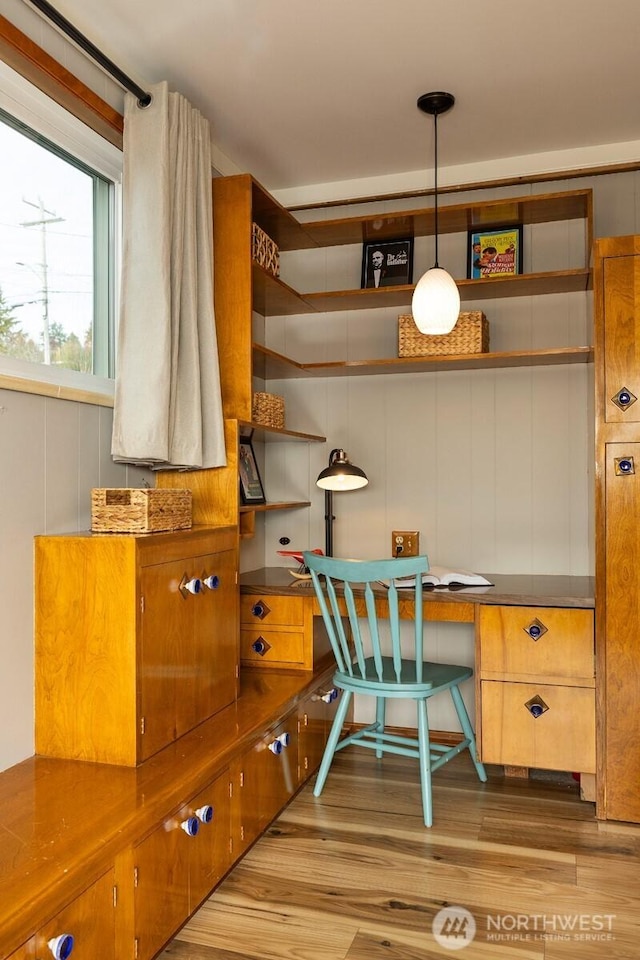 home office featuring built in desk and wood finished floors