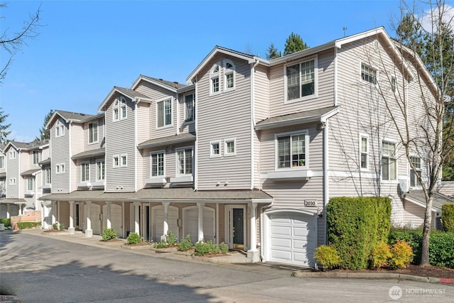 townhome / multi-family property featuring a garage and a residential view