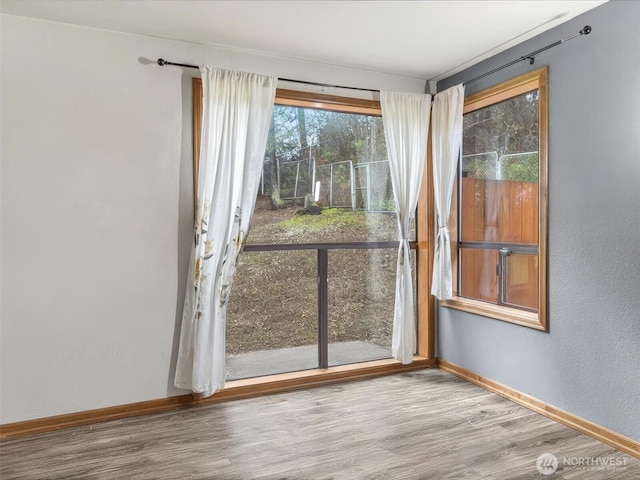 empty room featuring baseboards and wood finished floors