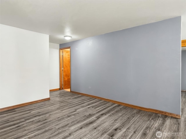 unfurnished room with baseboards and wood finished floors