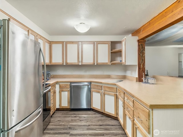 kitchen with dark wood finished floors, open shelves, stainless steel appliances, light countertops, and a peninsula