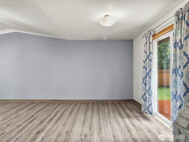 empty room with light wood finished floors and baseboards