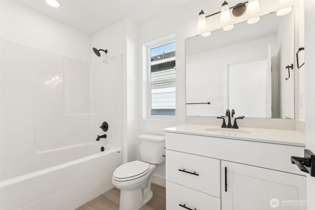 9701 205th St E Unit 28, Graham, WA 98338 - full bathroom featuring vanity, toilet, wood finished floors, and shower / bathtub combination
