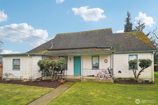 view of front facade with covered porch, a shingled roof, and a front yard