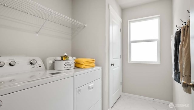 laundry area with laundry area, baseboards, and washing machine and clothes dryer