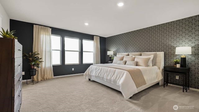 bedroom with light carpet, wallpapered walls, baseboards, an accent wall, and recessed lighting