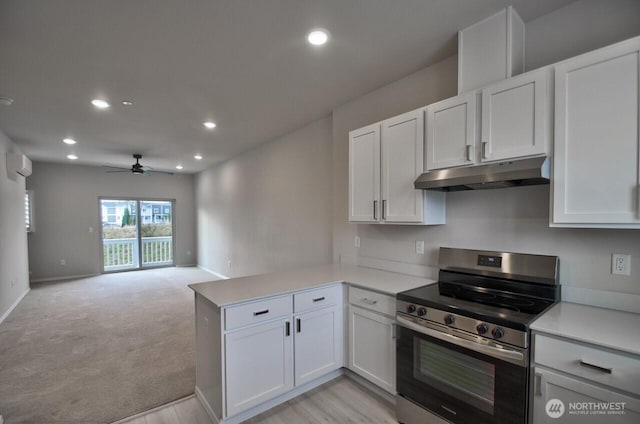 kitchen featuring under cabinet range hood, a peninsula, electric stove, light countertops, and a wall mounted air conditioner