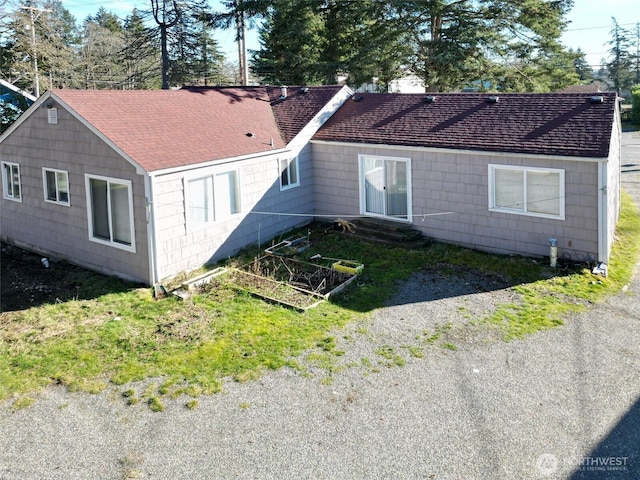 exterior space with a shingled roof and driveway