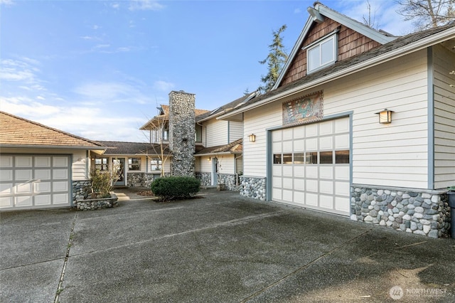 view of property exterior featuring stone siding and concrete driveway